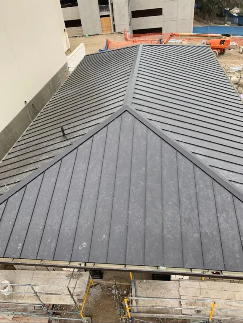 Commercial metal roof construction with crane equipment in Elbridge