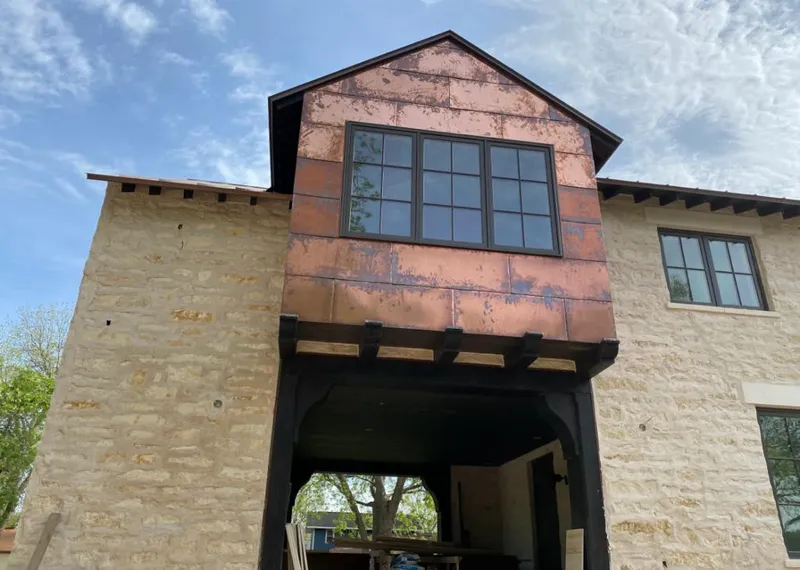 Copper metal panel facade on a stone building for Skylight Installation in Elbridge